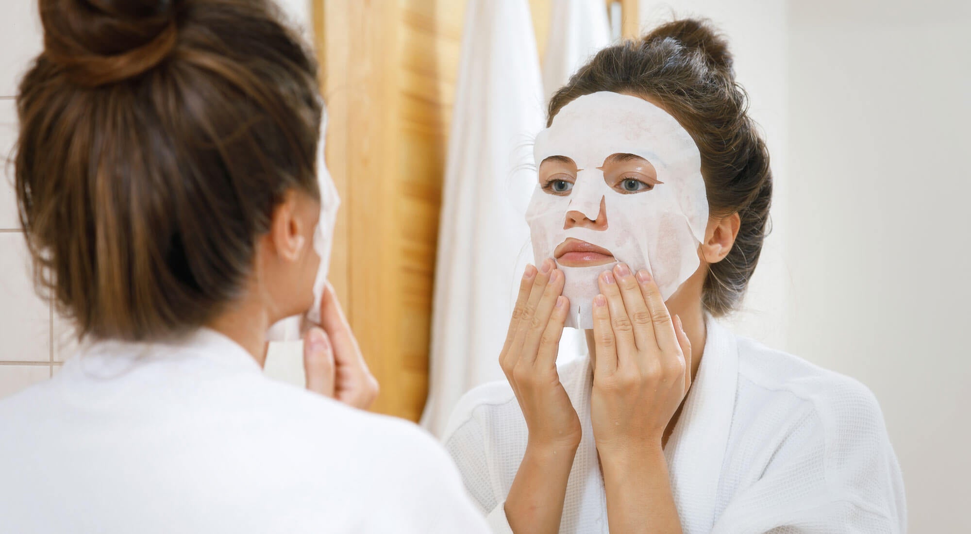 woman applying organic sheet mask