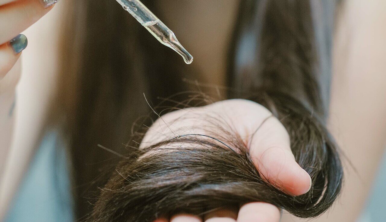 Main_woman applying oil onto her hair.jpg