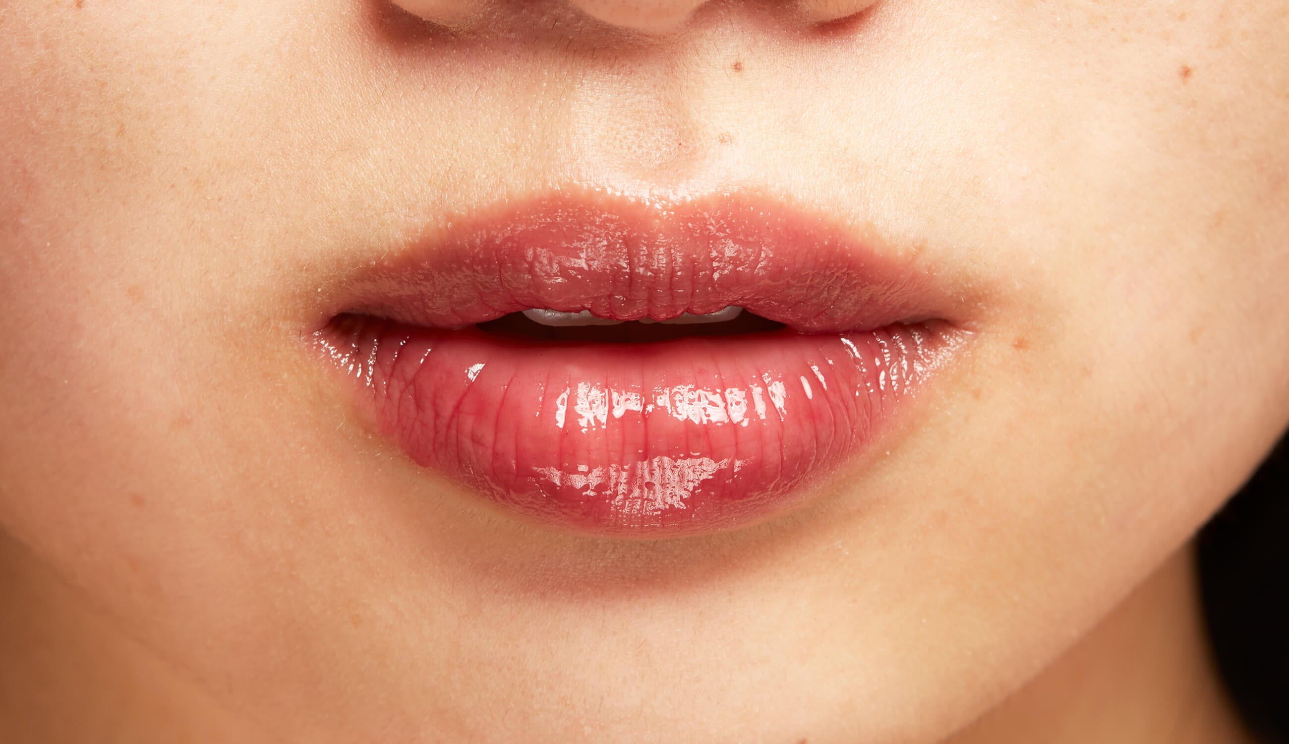 Lips applying rich, glossy lipstick color