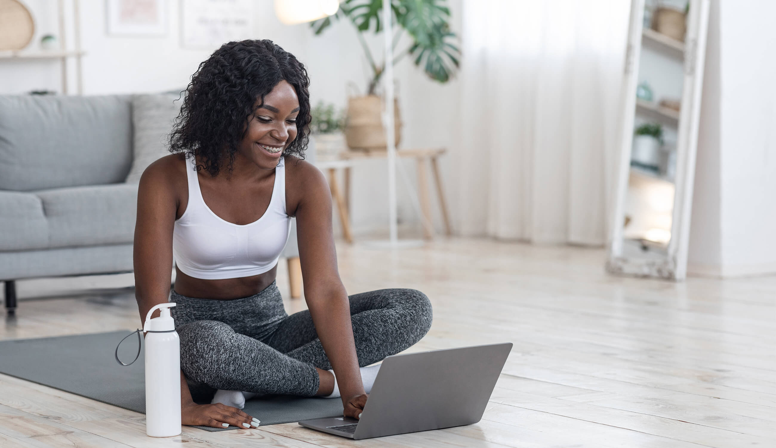 Main_woman using laptop on yoga mat.jpg