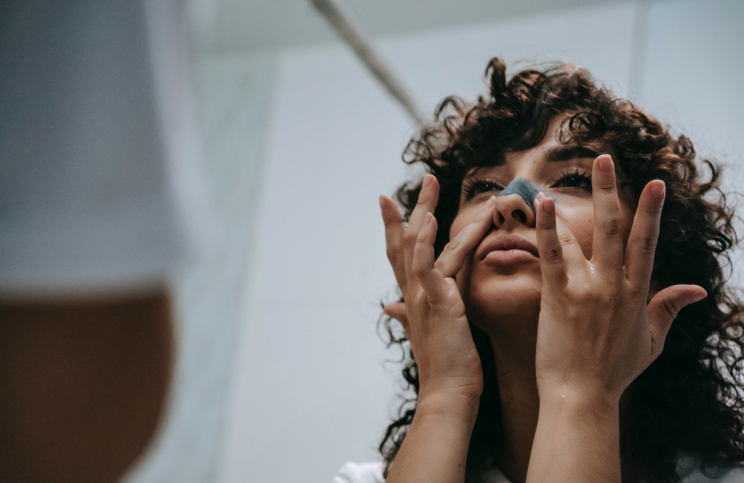 Woman placing pore strip on skin