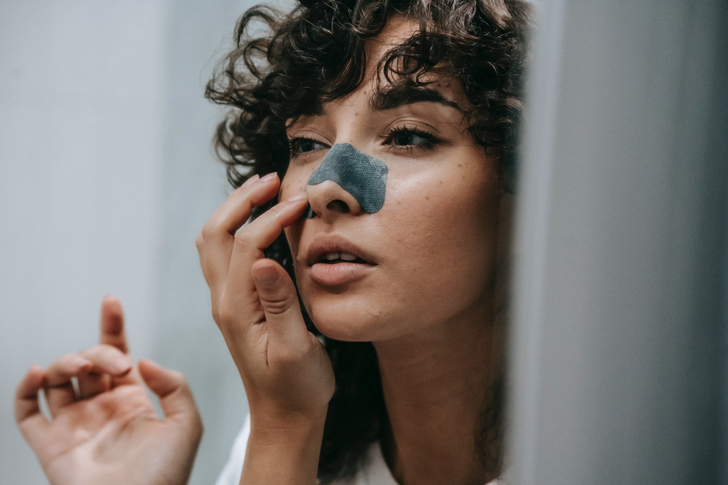 Woman using pore strip on face