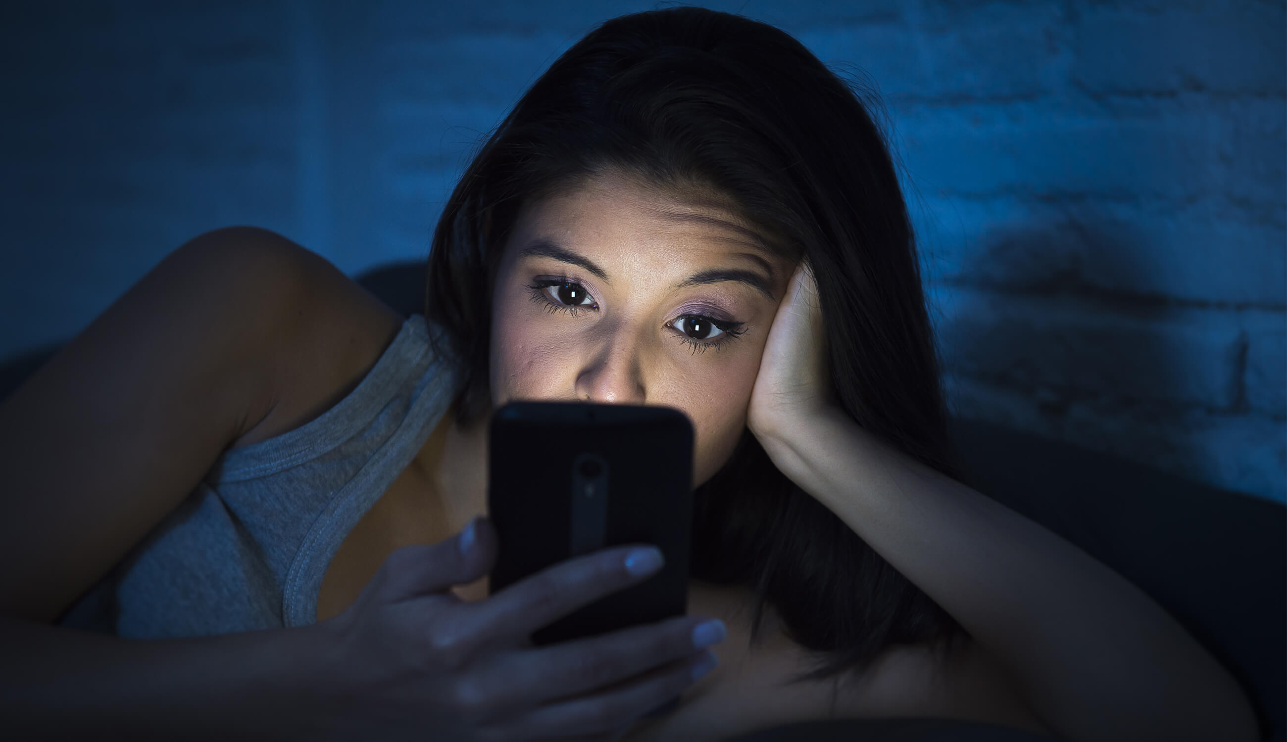 woman looking at phone in bed.jpg